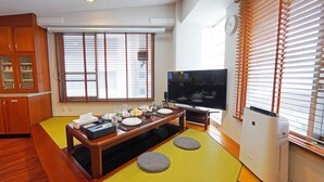 Un salon moderne avec une table à manger, un téléviseur et un appareil de climatisation.