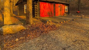 A rustic cabin with a red door and a small porch. - Lake Road Cabin C — Million Dollar Ozark View! (Ironton)