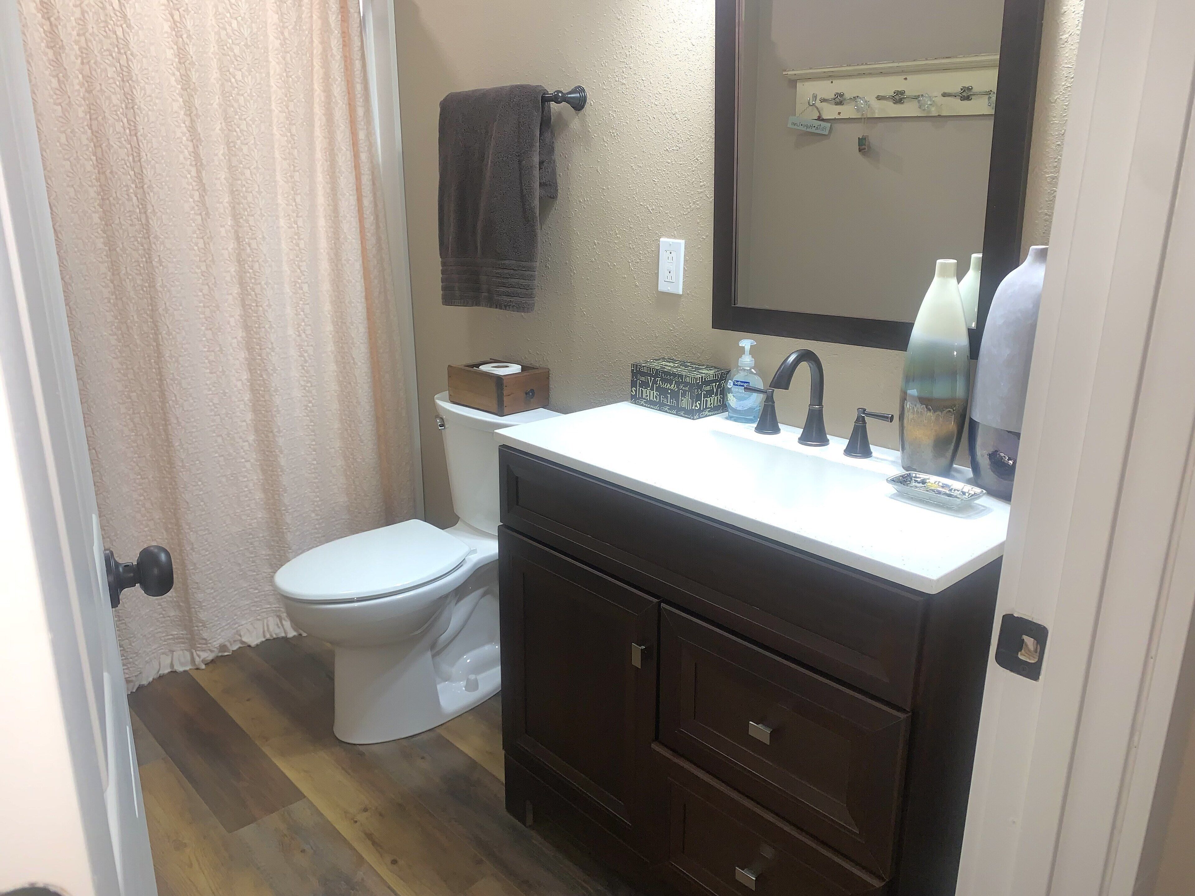 A bathroom with a toilet, sink, and mirror.