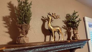 A shelf with three potted plants and a golden deer figurine.