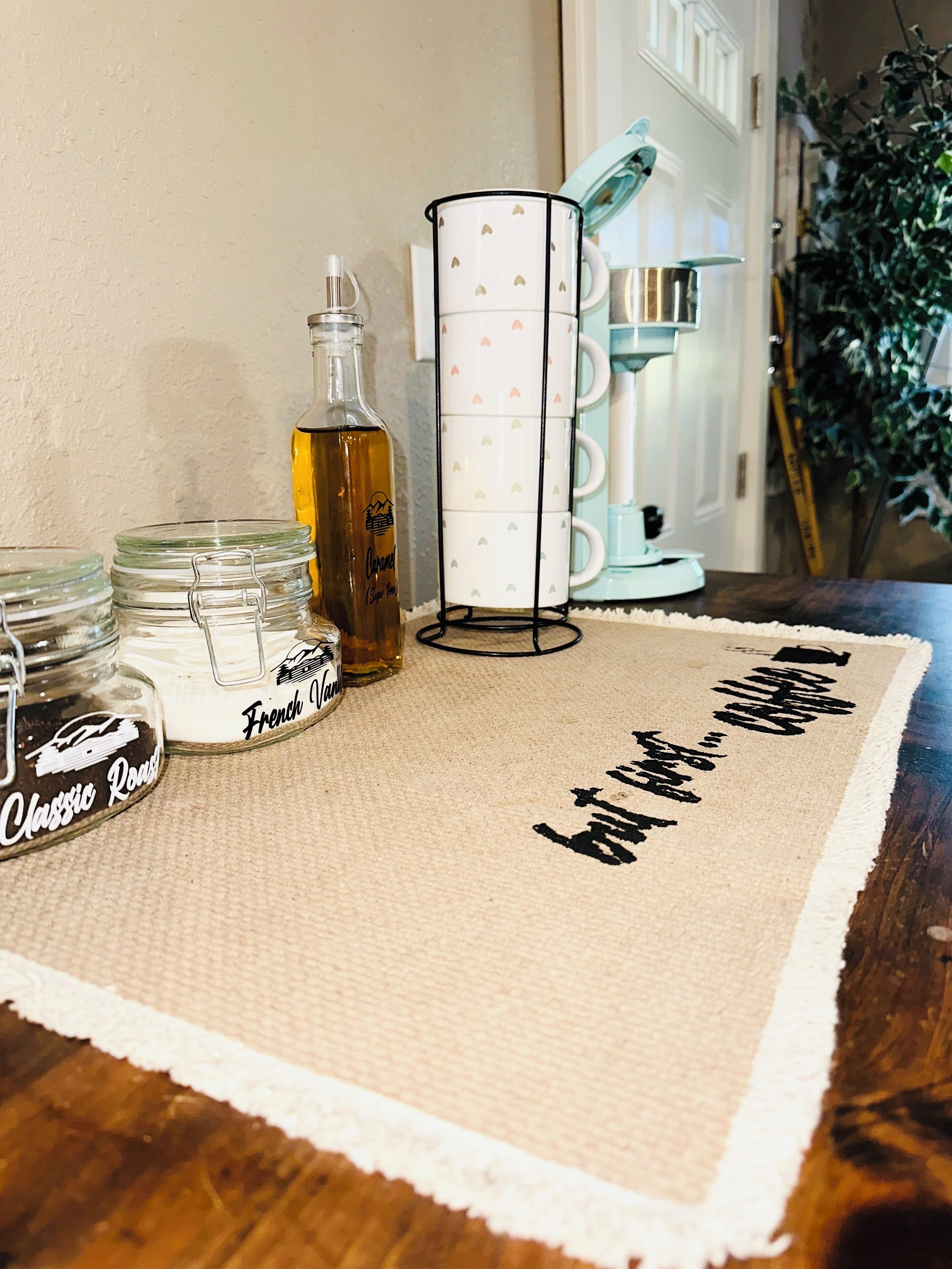 A kitchen counter with a coffee maker, a bottle, and jars labeled "Classic Roast" and "French Vanilla".