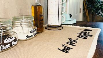A kitchen counter with a coffee maker, a bottle, and jars labeled "Classic Roast" and "French Vanilla".