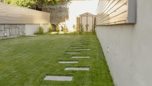 A well-maintained grassy area with stepping stones leading to a shed. - Legacy Oporto Premium Apartment B by Vacationy (Porto)