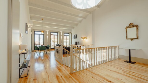 A spacious interior with a wooden floor, a staircase with a white railing, and a large circular skylight. - Legacy Oporto Premium Apartment I by Vacationy (Porto)