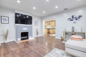 Cozy living room with a fireplace, flat-screen TV, and comfortable sofa.