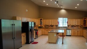 Una cocina amplia con armarios de madera, electrodomésticos de acero inoxidable y una isla central.