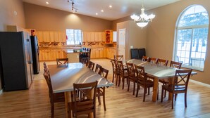 Una cocina amplia con armarios de madera, una isla grande y un comedor con una mesa larga y sillas.