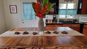 Une table de salle à manger en bois, agrémentée d’un vase tressé et d’objets décoratifs.