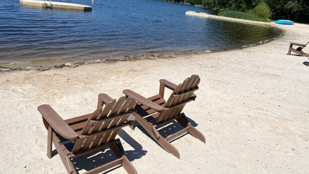 A sandy beach with two wooden Adirondack chairs facing a lake. - BICKING & Fishing, National Parks .Water park. Shooting. Gamblingnd. IPA at PA.  (Clifton)