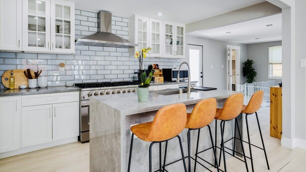 A modern kitchen with white cabinets, a large island with bar stools, a stainless steel stove, and a backsplash of white tiles. - modERn Luxury Home🌇🎆🌉Limited time offer! (Walnut Creek)
