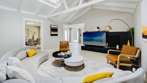 A spacious living room with a high ceiling, a large flat-screen TV, and a dining area in the background. - modERn Luxury Home🌇🎆🌉Limited time offer! (Walnut Creek)