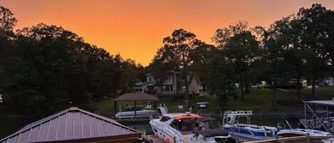 A marina with docked boats, a gazebo, and a house in the background.
