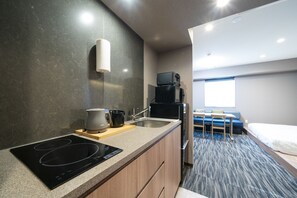 A compact kitchen with an induction cooktop, a coffee maker, and a microwave. - KOKO HOTEL Residence Asakusa Kappabashi (Tokyo)