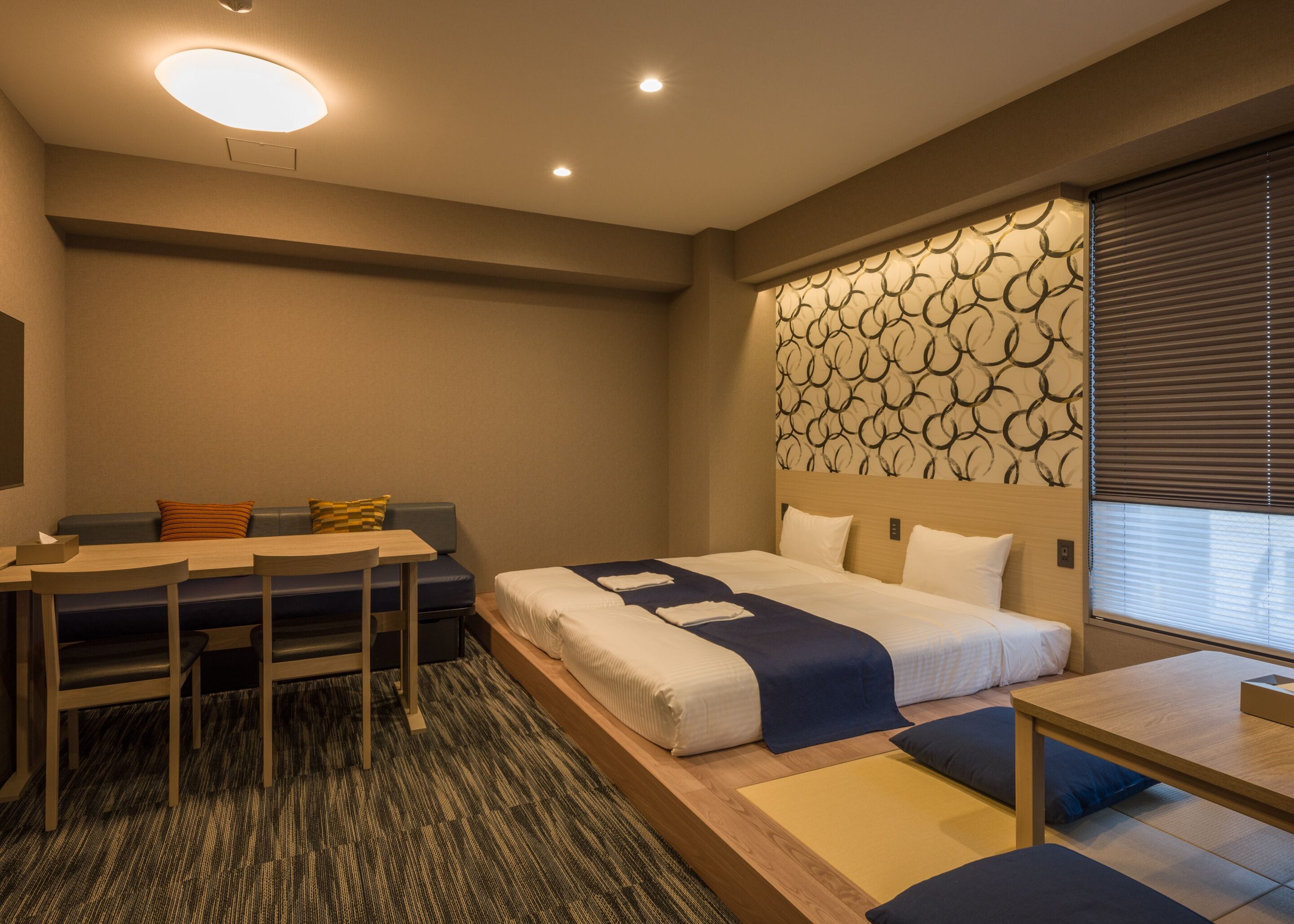 Una habitació d'hotel amb un llit, una taula de treball i una zona de seients.