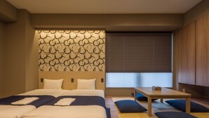 Una habitación de hotel moderna con una cama grande, un cabecero de madera, una mesita y una ventana con persianas.