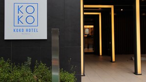Señal del Koko Hotel Residence, con una entrada moderna que presenta marcos iluminados.