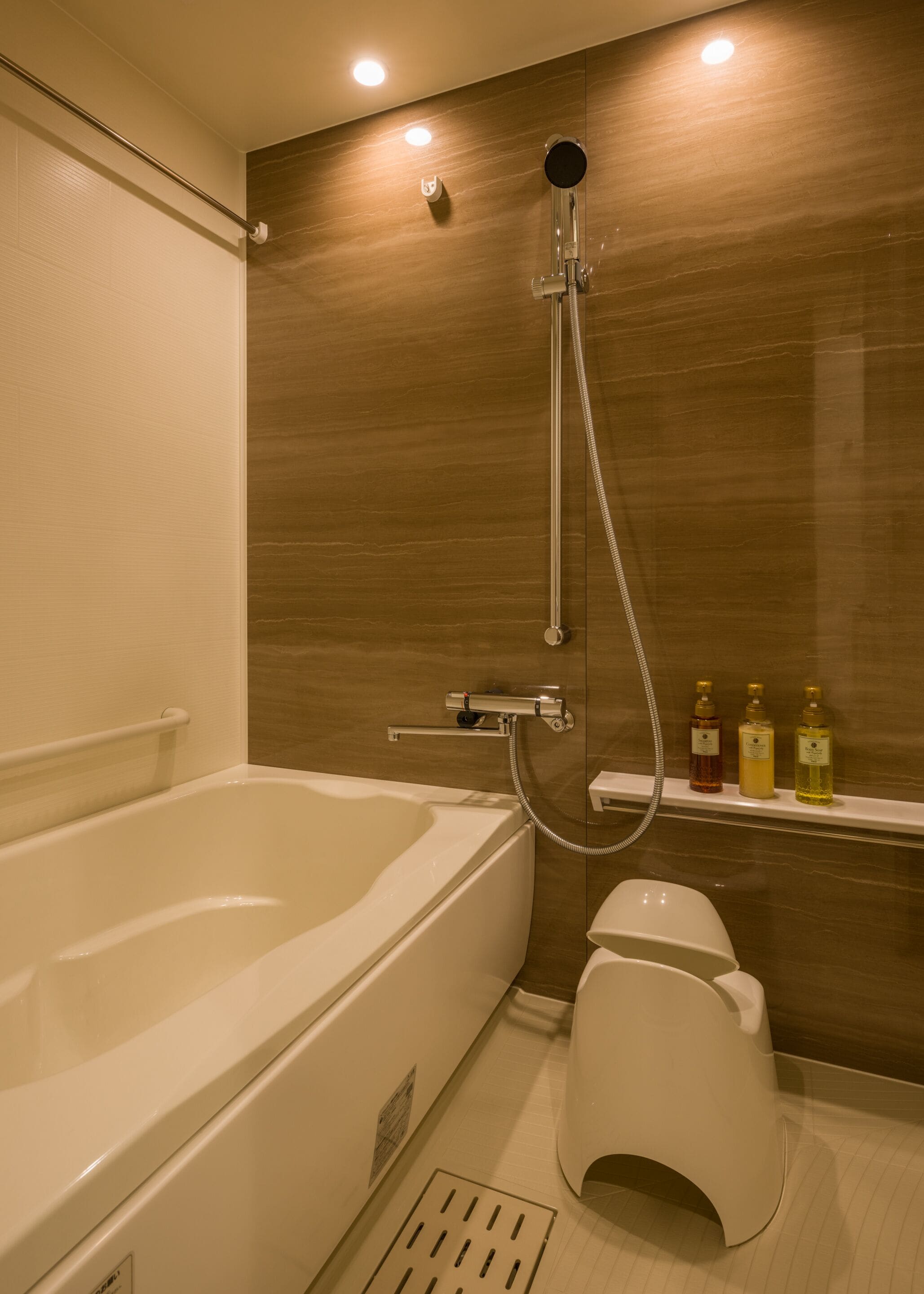 A modern bathroom with a bathtub, shower, and toilet.