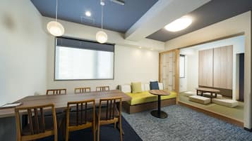 A modern meeting room with a wooden table, chairs, a sofa, and a small round table.
