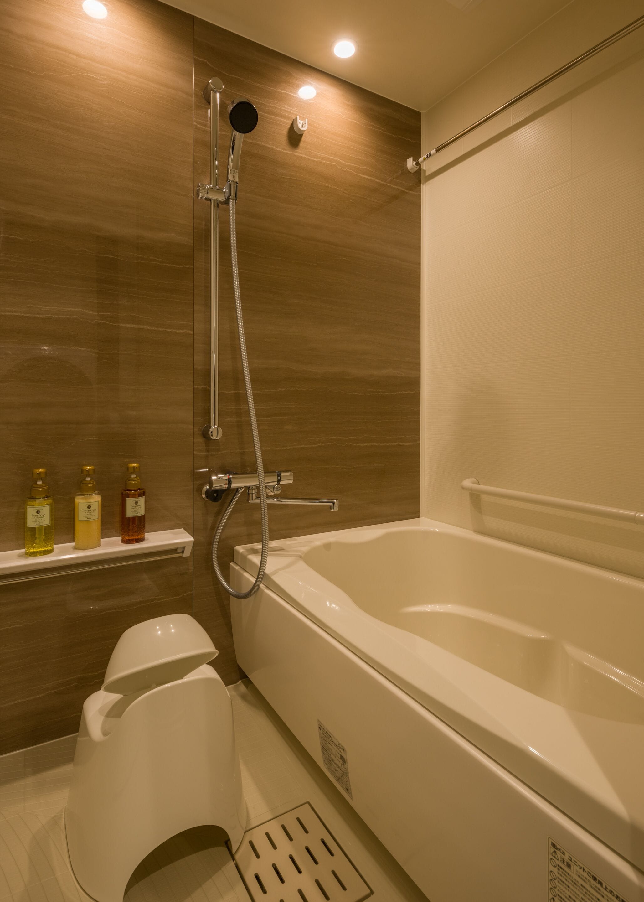 A modern bathroom with a bathtub, shower, and toilet.