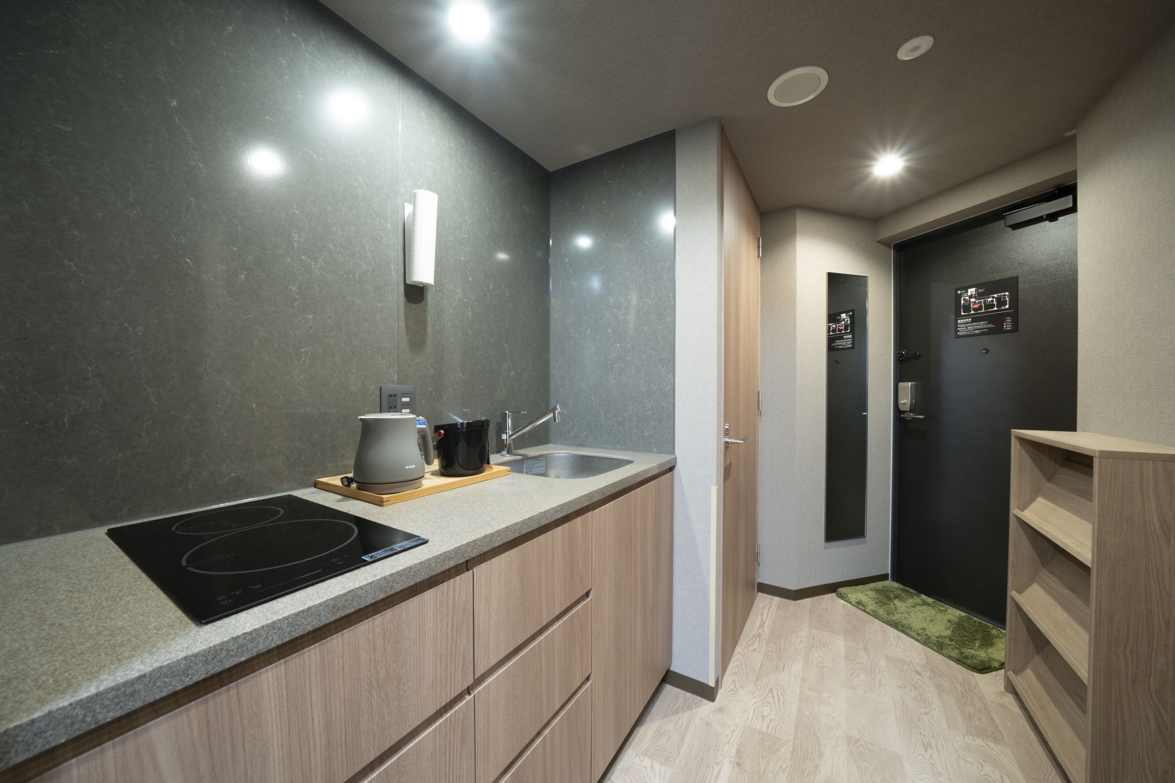 A modern kitchen with a built-in stove, a sink, and wooden cabinets.