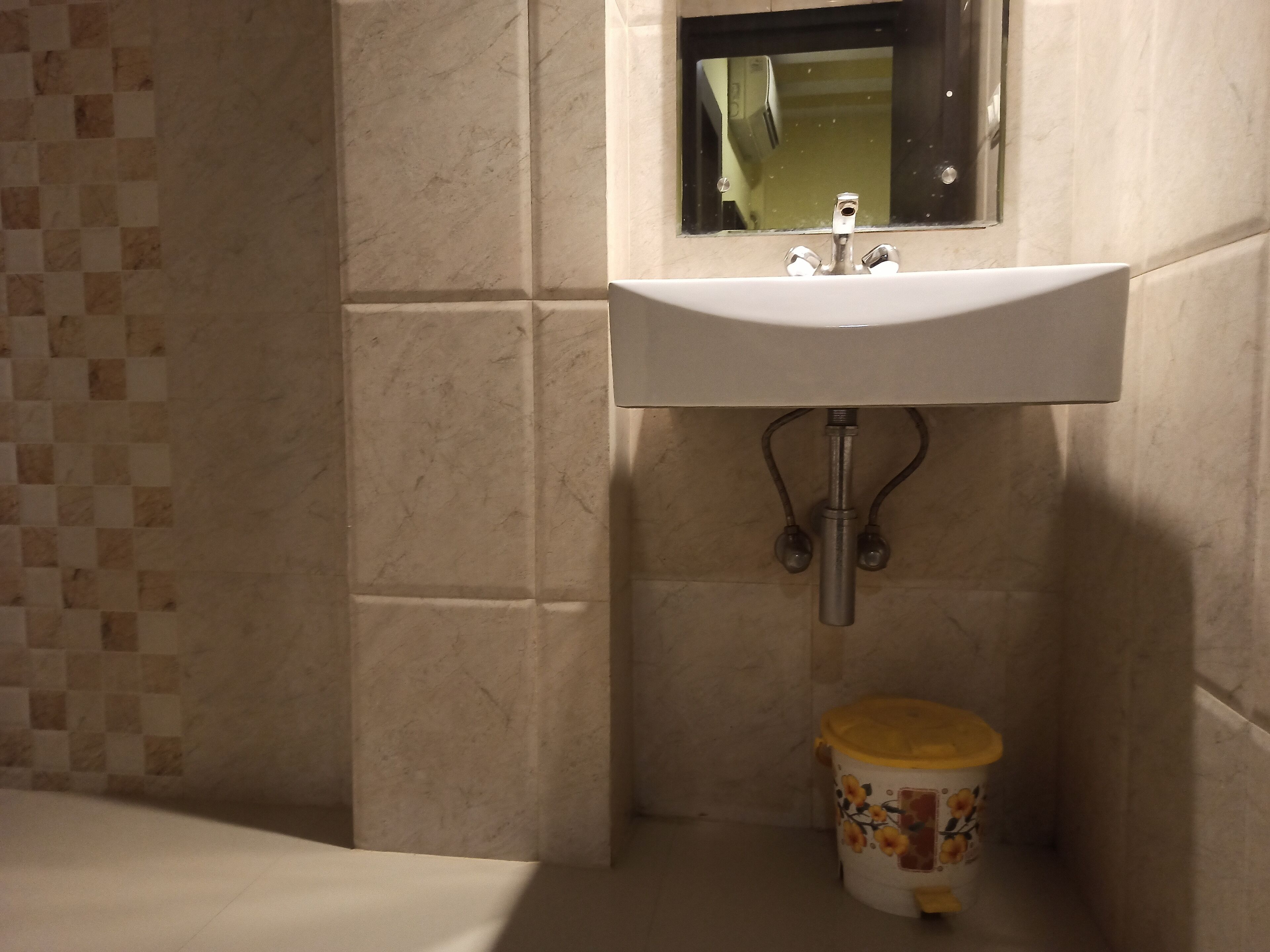 Een badkamer met een wastafel, spiegel en toilet.