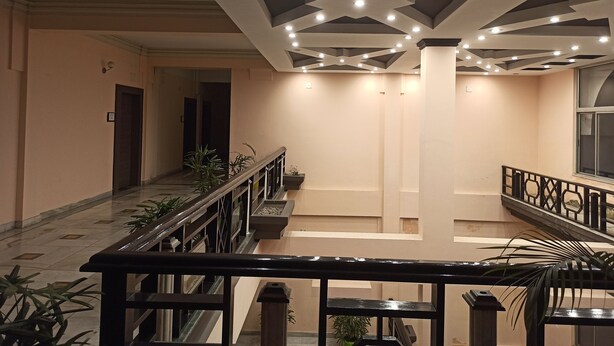 A spacious interior with a high ceiling, modern lighting, and a central column. - Hotel Centre Point (Tinsukia)