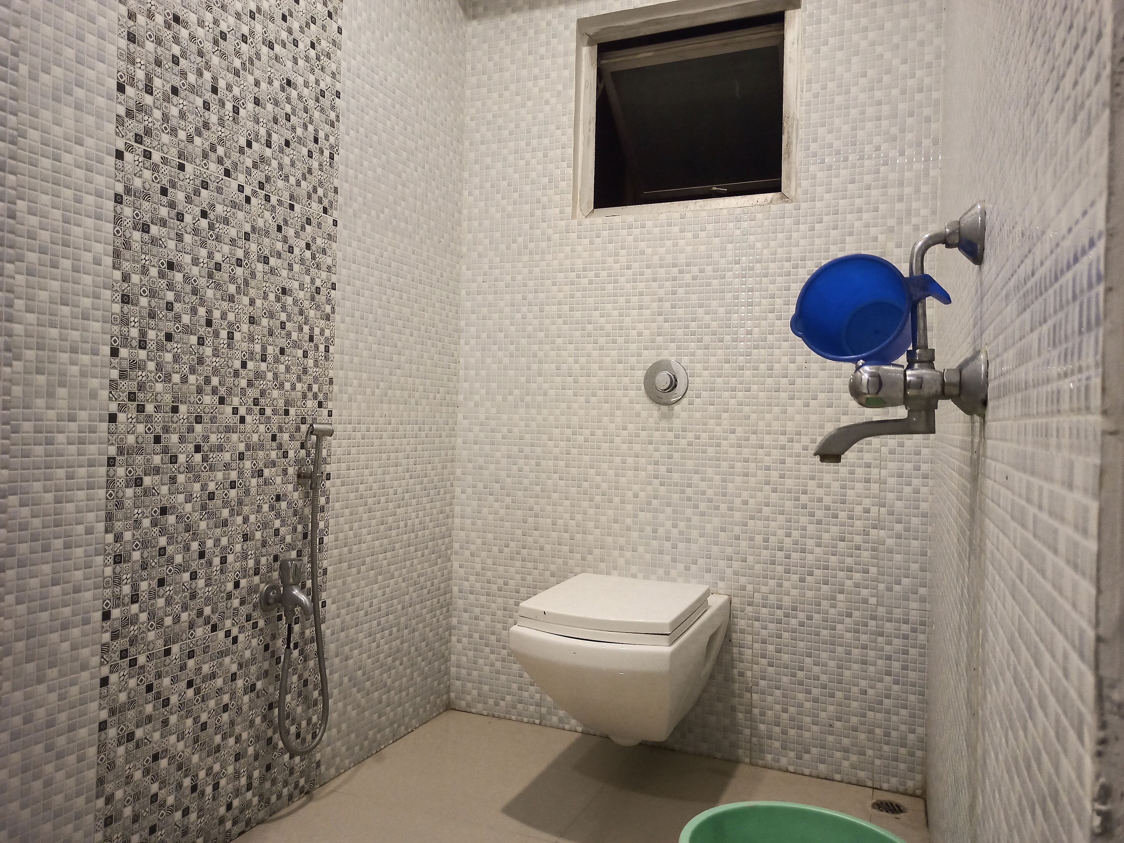 Un baño pequeño con inodoro, ducha y ventana.