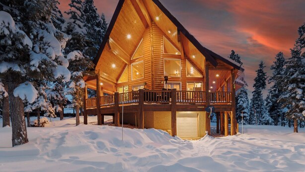 A log cabin with a balcony, surrounded by snow-covered trees. - Pet Friendly | EV Charger| Zion/Bryce Hub | Family Fun (Duck Creek Village)