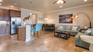 A spacious living area with a kitchen, dining table, and seating.