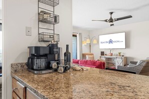 A modern kitchen with a coffee maker, wine bottle, and storage baskets. - Amazing Lake View Walk-In Condo, Newly Renovated Spacious Near Silver Dollar City with Free Tickets (Branson)