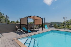 A swimming pool with a wooden deck, lounge chairs, a covered seating area, and a view of the landscape. - Amazing Lake View Walk-In Condo, Newly Renovated Spacious Near Silver Dollar City with Free Tickets (Branson)