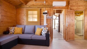 A wooden interior with a sofa, a door, and a hallway leading to a shower area. - Holiday home La Cabañita de Javi with Sea View, Garden & Wi-Fi (Tuineje)
