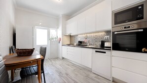 A modern kitchen with white cabinets, a microwave, and an oven. - Apartment Casa Violeta with Terrace, A/C & Wi-Fi (Lagos)