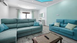 A modern living room with two sofas, a coffee table, and a ceiling with recessed lighting. - Apartment Casa Violeta with Terrace, A/C & Wi-Fi (Lagos)