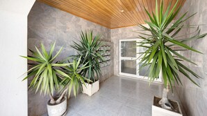 A modern interior with a wooden ceiling, grey stone walls, and potted plants. - Apartment Casa Violeta with Terrace, A/C & Wi-Fi (Lagos)