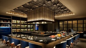 A modern bar area with a central island, bar stools, and a ceiling with a grid pattern. - Fuji Speedway Hotel - The Unbound Collection by Hyatt (Oyama)