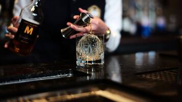 Iemand giet een drankje in van een fles in een glas.