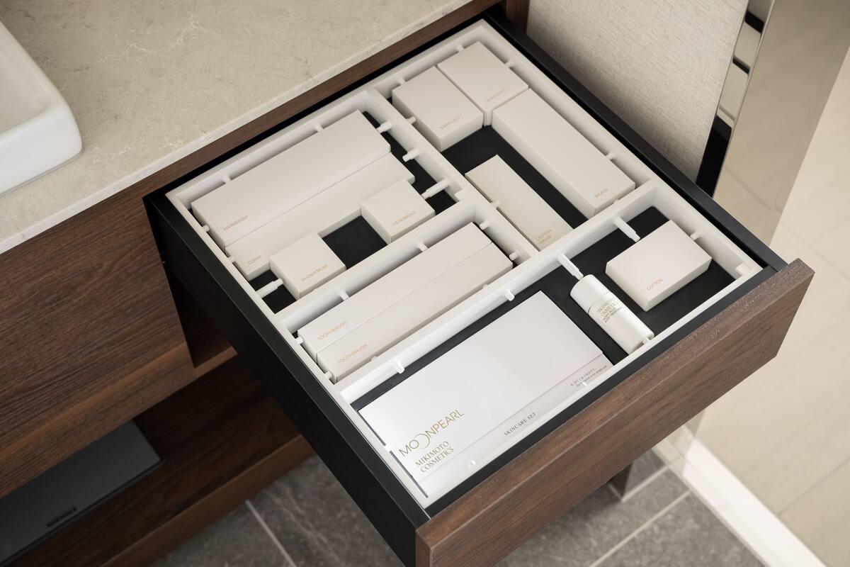 A drawer with neatly organized compartments containing various skincare products.
