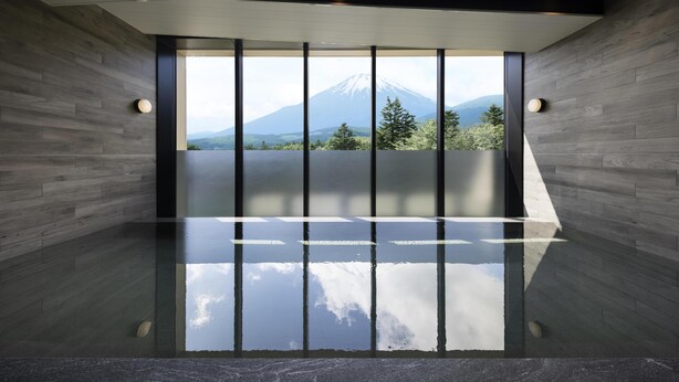Un intérieur moderne avec une grande fenêtre, des murs en bois et une vue sur une montagne.