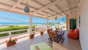 A covered patio with a view of the sea, a dining table, chairs, and a bean bag. - Villa Renzo Large Private Pool Sea Views A C Wifi (Scicli)