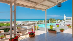 A covered outdoor area with a pool, potted plants, and a view of the sea. - Villa Renzo Large Private Pool Sea Views A C Wifi (Scicli)