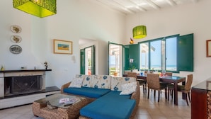 A cozy living room with a fireplace, a sofa set, and a dining area with a view. - Villa Renzo Large Private Pool Sea Views A C Wifi (Scicli)