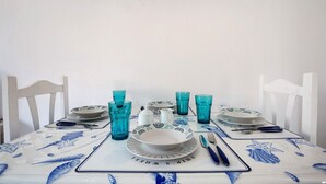 Una mesa de comedor dispuesta con platos, vasos y cubiertos.