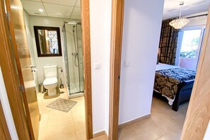 Une chambre d’hôtel équipée d’une douche, de toilettes, d’un lit et offrant une vue sur l’extérieur.