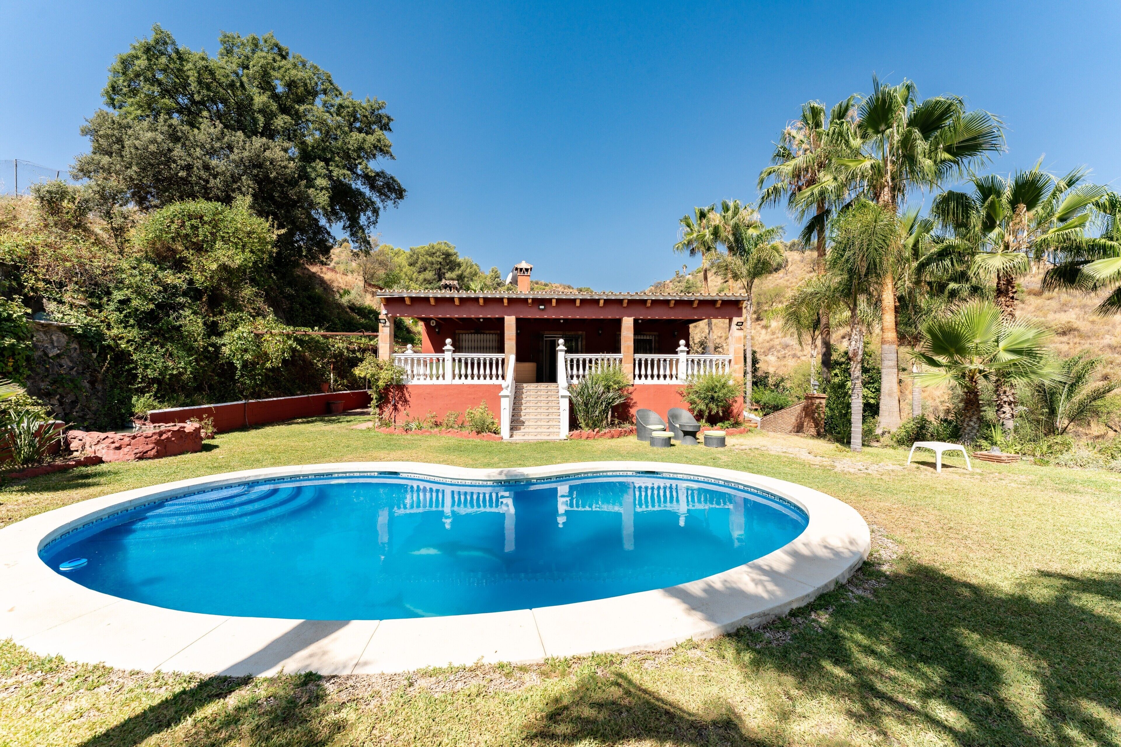 En swimmingpool med et hus i baggrunden.