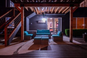 A wooden deck with a sofa and ottoman set, a staircase, and a sign reading "Welcome to our home". - Home: Sleeps 4, Bedroom, Living, Bath, Office, Patio (Bothell)