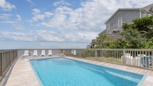 A rectangular swimming pool with a wooden deck, surrounded by a wooden fence. - 7815-Tarhoo, | Soundfront Frisco Retreat | Pool & Sunset Views (Frisco)