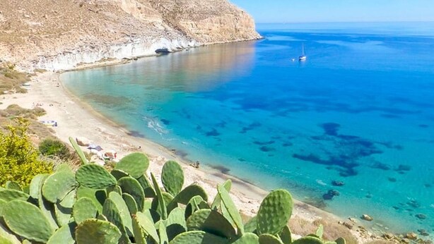 A coastal landscape with a clear blue sea, a sandy beach, and a rocky cliff. - Marvel Apartment with Pool near Playa Vera (Vera Playa)