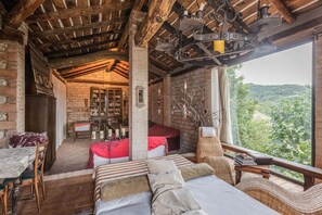 Una habitación rústica con techo de madera, una cama, una mesa de comedor y vistas al exterior.