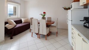 A compact living space with a dining area, a sofa, and a kitchenette. - Modern apartment in Dramalj near the sea (Dramalj)
